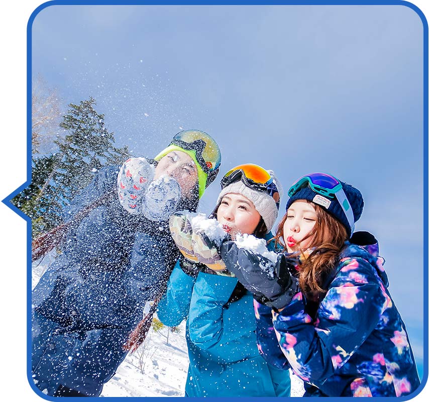 青空の下で楽しそうにしている女性３名のスノーボーダー