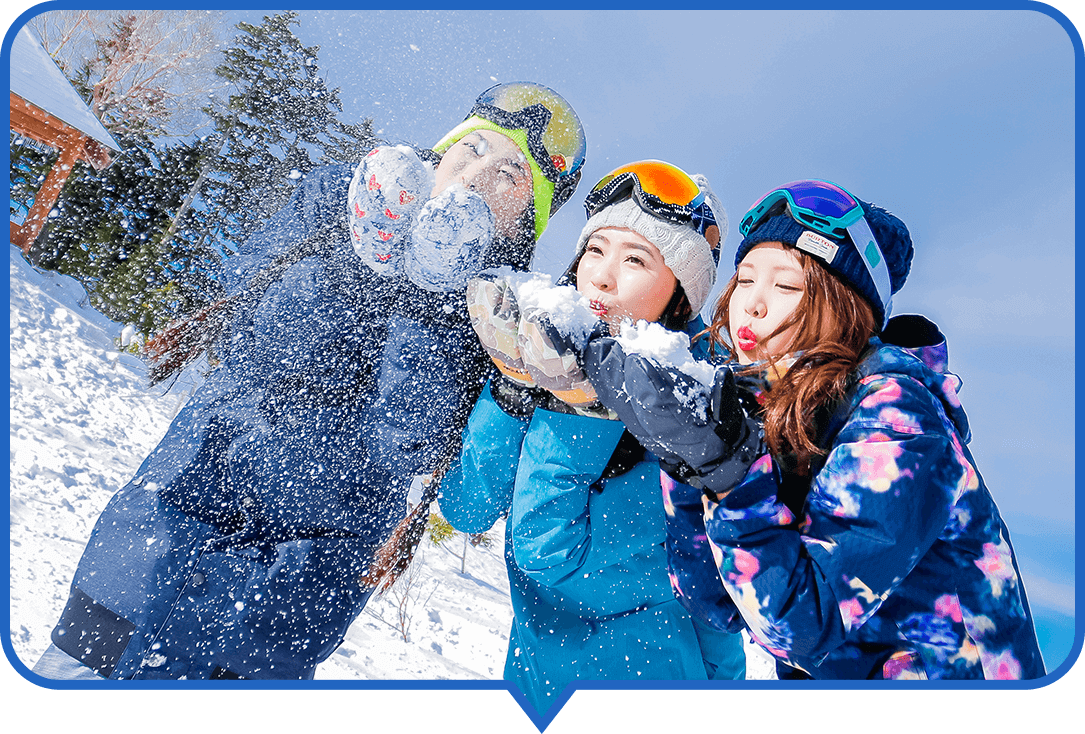 青空の下で楽しそうにしている女性３名のスノーボーダー