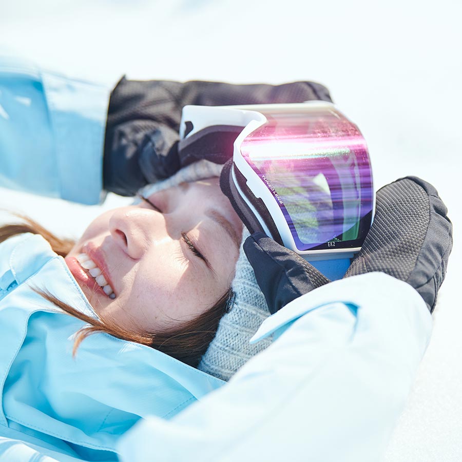 スキーウェア姿で、雪の上に仰向けになって楽しんでいる様子