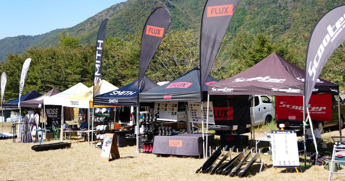 屋外に並ぶFLUXとScooterなどの試乗テントとブーツ・ボードの展示