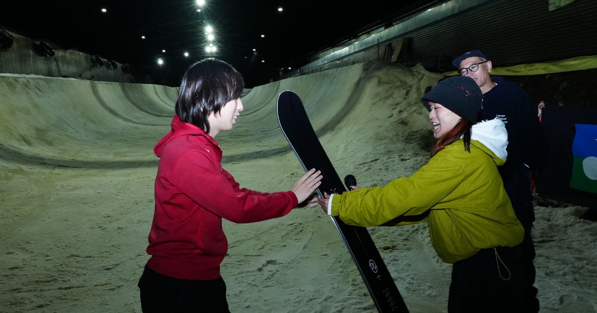 大抽選会の景品のスノーボードを持って記念撮影する当選者